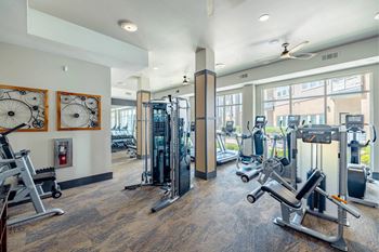 A gym with a variety of equipment including treadmills, weights, and exercise machines.